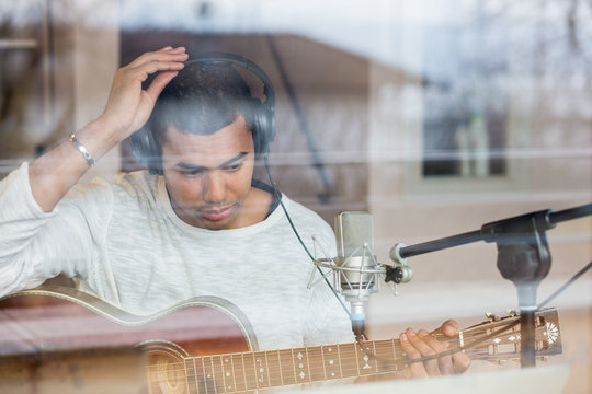 Man with guitar sitting in studio