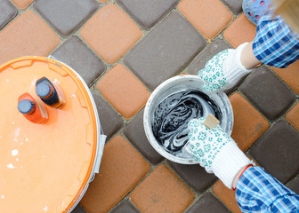 female hands mixed acrylic colors in a plastic box