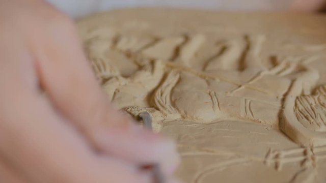 Professional male potter making clay stamp picture. Handwork, crafting and traditional arts concept
