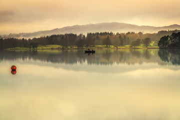Early morning mist on Lake Windermere the largest natural lake in England. It is a ribbon lake...