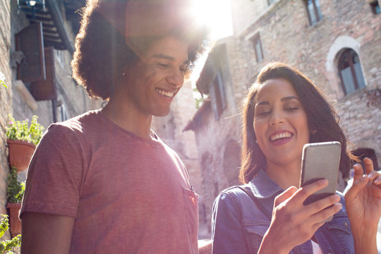 Young couple using smartphone while standing outdoors