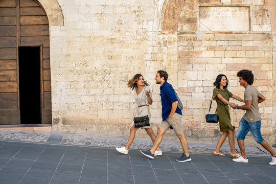 Smiling young couples walking in alley