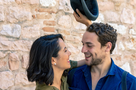 Smiling friends standing against brick wall