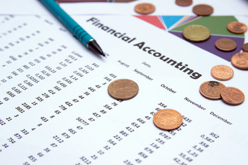 Financial accounting, Image a plurality of numbers on paper and calculator, Numbers on paper, a pen and a calculator, coins.