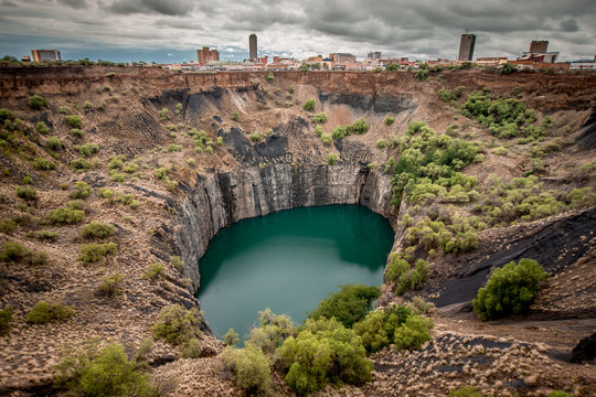 Wide view of The Big Hole in Kimberley, a result of the mining industry, with the town skyline on the edge