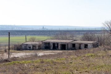 Abandoned building on the background of green fields and mountains