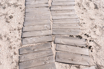 The path to the sea is crookedly paved with wooden planks. Space for text, empty cells.