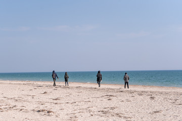 People walk along the sea beach in the resort town in the spring in the off-season. 