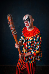 Crazy bloody clown with baseball bat