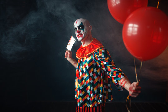 Bloody clown with meat cleaver holds air balloon