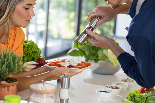 Couple preparing salad in kitchen