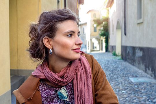 Thoughtful brunette woman standing outdoors