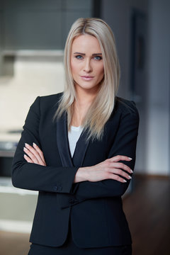 Nice and calm blond, middle age business woman standing at her office