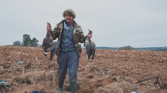 Portrait of a hunter with dead geese. Extraction. Goose Hunter. hunting trophy