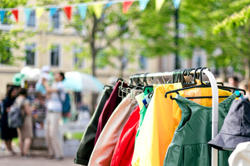Clothes on the rail on the summer outdoor vintage fashion designer market. Garage sale, reuse the...