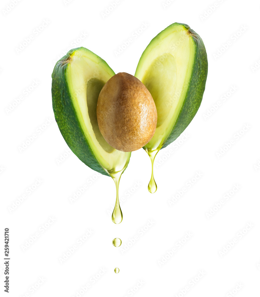 Wall mural drops of oil dripping from avocado, isolated on white background