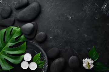 Fotobehang Zen stenen en bladeren met waterdruppels. Spa-achtergrond met spa-accessoires op een donkere achtergrond. Bovenaanzicht. Vrije ruimte voor uw tekst. © Yaruniv-Studio