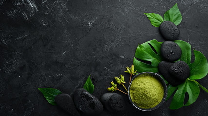 Zen stones and leaves with water drops. Spa background with spa accessories on a dark background. Top view. Free space for your text.