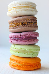 Colorful French or Italian macaroon stack cakes / Macaroon cakes. Assorted macaroon cakes stacked on top of each other on a light background. Copy space. Delicious dessert.