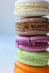 Colorful French or Italian macaroon stack cakes / Macaroon cakes. Assorted macaroon cakes stacked on top of each other on a light background. Copy space. Delicious dessert.
