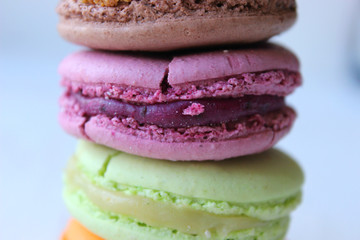 Colorful French or Italian macaroon stack cakes / Macaroon cakes. Assorted macaroon cakes stacked on top of each other on a light background. Copy space. Delicious dessert.