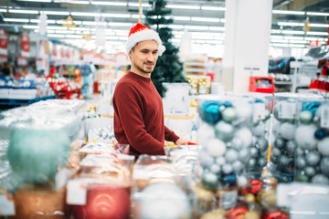 Man chooses christmas decorations in supermarket