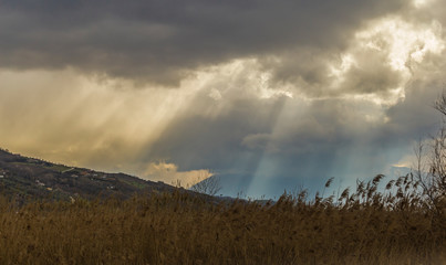 stormy sky with a dramatic sunbeam on a rural background