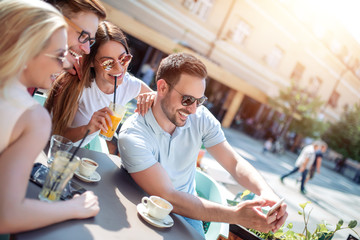 Cheerful group of friends having fun in cafe