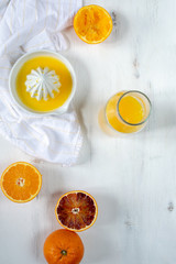Fresh juicy oranges, fresh squeezed orange juice, refreshing summer drink, white wooden background