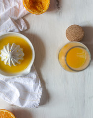 Fresh juicy oranges, fresh squeezed orange juice, refreshing summer drink, white wooden background