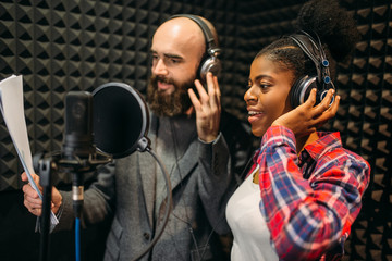 Male and female singers in audio recording studio