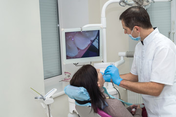 Dentist checking patient's teeth with camera in stomatology
