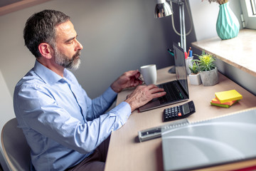 Senior man working on laptop computer