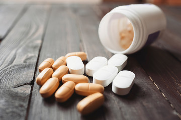 Fototapeta na wymiar Pills, antidepressants closeup on a dark wooden background