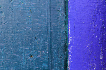 Obraz premium Old wooden background with remains of pieces of scraps of old paint on wood. Texture of an old tree, vintage wood background peeling paint. old blue board with cracked paint