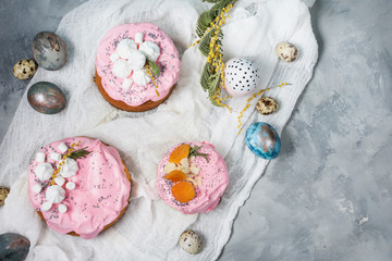 Easter composition with orthodox sweet bread, kulich and eggs on concrete background.