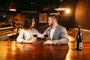 Man and woman flirting in bar, couple at counter