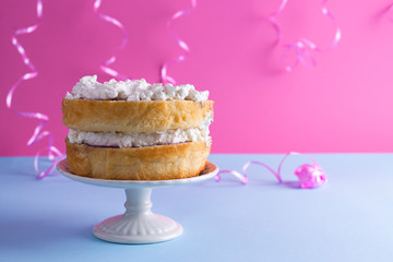 A festive sponge cake with white cream for a birthday, on a pink and blue background. Food for the holiday. Advertising poster and place for text. Copy cpace