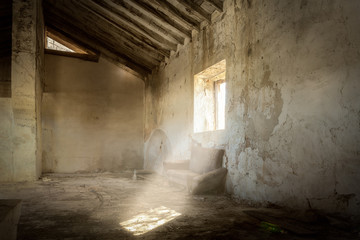Ein Schweinestall in einem verlassenen Bauernhaus. Die Sonne scheint durch das offene Fenster auf den verstaubten Boden.