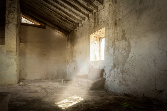 Ein Schweinestall in einem verlassenen Bauernhaus. Die Sonne scheint durch das offene Fenster auf den verstaubten Boden.