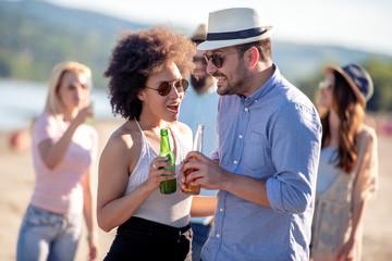 Happy couple drinking together on the beach