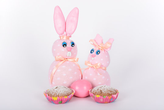 The pink easter male and female hand-made bunnies, easter egg and cakes