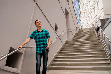 The young man is standing on the big stairs