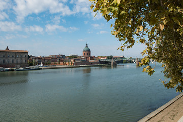 The Saint Pierre bridge passes over the Garonne river and Hospital de La Grave in Toulouse.