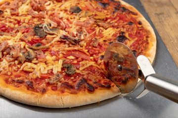 Pizza from the market and a knife for cutting the pizza. Fast food prepared in the home kitchen.