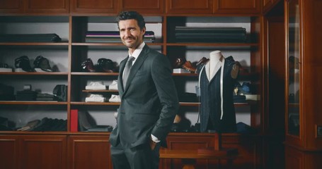 Slow motion of handsome businessman trying a new tailor made suit  in atelier.