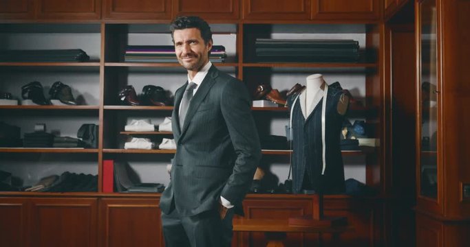 Slow motion of handsome businessman trying a new tailor made suit  in atelier.