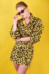 Fototapeta premium Charming blonde girl in casual animal printed clothes in a colorful background.