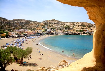 View from a cliff to Greek Matala Beach. Summer hollidays and vacation in Greece, Crete. - obrazy, fototapety, plakaty