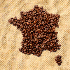 Whole bean coffee. The contour of the France is made of coffee beans on jute burlap